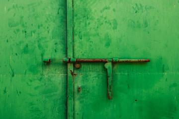 Close up of a latch on a green metal door