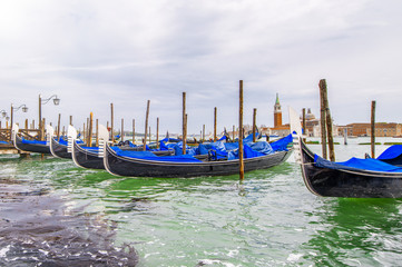 Fototapeta na wymiar Gondolas boats along city pier, Venice, Italy