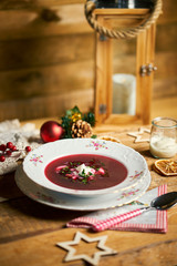Fototapeta na wymiar Traditional christmas red borscht on wooden table