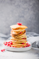 Homemade pancake or hot cake stacked on white plate with berry on grey stone Background,