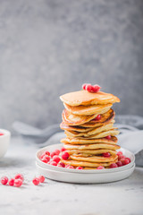 Homemade pancake or hot cake stacked on white plate with berry on grey stone Background, Christmas Dessert.