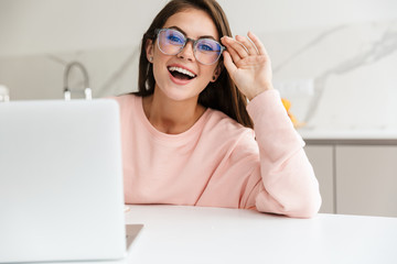 Smiling prettty girl working on laptop computer