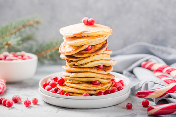 Homemade pancake or hot cake stacked on white plate with berry on grey stone Background, Christmas Dessert.