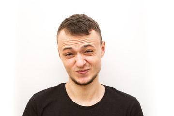 Obraz premium emotion grimacing, young man in a black cap on a white background, man emoji