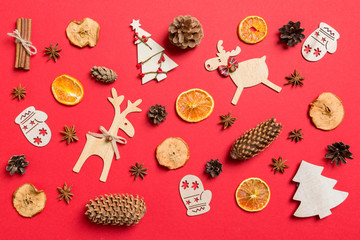 Top view of red background decorated with festive toys and Christmas symbols reindeers and New Year trees. Holiday concept