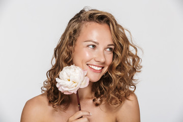 Image of pleased half-naked woman with peony smiling and looking aside © Drobot Dean