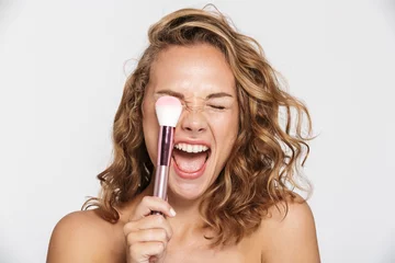 Poster Image of half-naked woman making fun with makeup brush and screaming © Drobot Dean