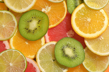 Fototapeta na wymiar Fruit Slices Background With Lemon, Lime, Kiwi, Orange
