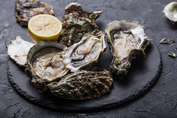 Fresh open Oysters. Healthy sea food. Dinner in restaurant. Gourmet food. Dark background. Top view