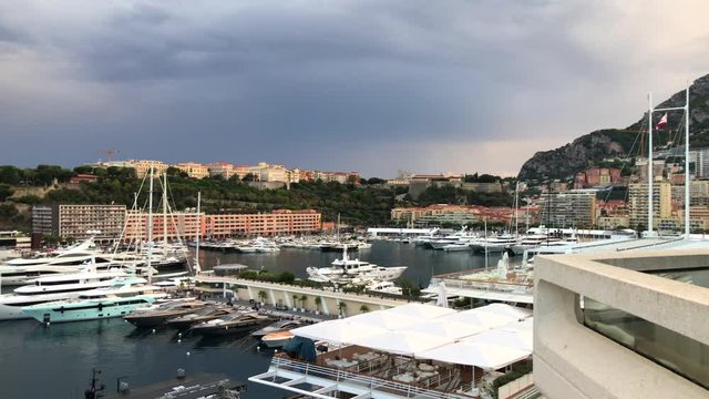 Port Hercules with big yachts and boats on a cloudy day with tall buildings, popular tourist location, luxury lifestyle