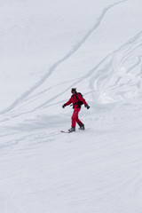 Fototapeta na wymiar Snowboarder downhill on snowy off-piste slope after snowfall