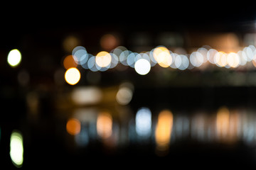 Colorful bokeh light, reflecting in the water of a harbor