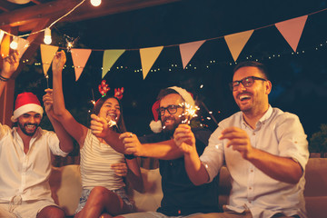 Friends having fun with sparklers at New Year party