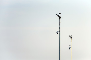 cctv cameras on metal stand over cloudy sky in uk
