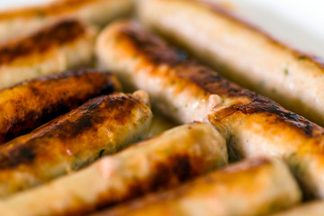fried german bockwurst sausage in a pan. closeup view