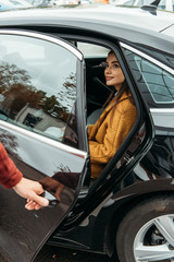 Smiling woman passenger while taxi driver opening car door © LIGHTFIELD STUDIOS