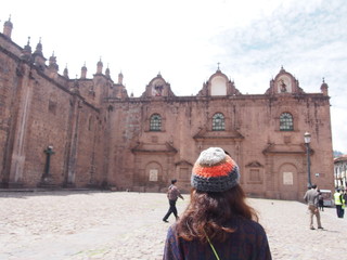 A woman looking at a historic building, Cusco, Peru