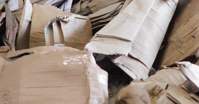 Large warehouse of waste paper in plant. Warehouse with recyclable materials at garbage processing factory. Huge pile of different paper pieces, rubbish, litter, trash, closeup view in motion.