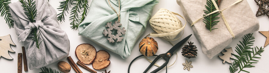 Fabric wrapped gifts and wooden Christmas decorations - obrazy, fototapety, plakaty