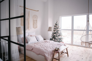 Interior of a bedroom with a Christmas tree and gifts