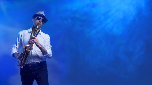 Man spielt Saxophon im blauen Lasernebel