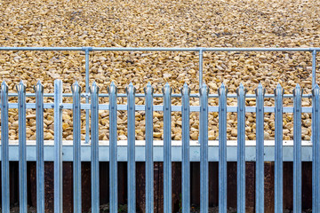railroad metal fence over gravel background in england uk