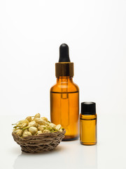 jasmine essential oil with dried jasmine on white background
