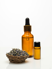 lavender essential oil with dried lavender on white background