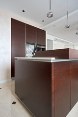 Modern bright kitchen with island and walnut veneer facades