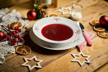 Traditional christmas red borscht on wooden table