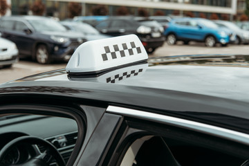 Black and white taxi sign on car roof