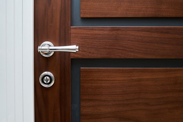 Obraz premium Details doors made of walnut wood in a classic style with the white trim in the hallway