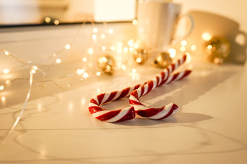 Christmas candies, on a white background, golden toys and garlands on the window
