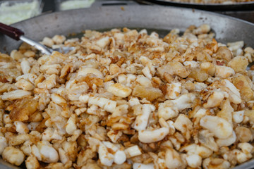 Freshly cooked stir fried squid eggs on flat pan for sale in a local street food fresh market in Bangkok, Thailand.