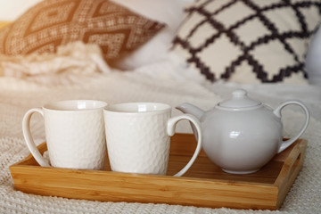Fototapeta na wymiar tray of white tea set on bed in bedroom, sunlight