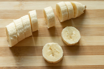 cut banana fresh fruit for breakfast dessert food photography on wooden background top view 