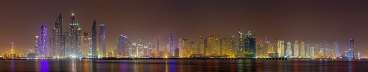 Fototapeta na wymiar Dubai - The evening panorama of Marina towers from Palm Island.