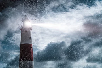  Large lighthouse with bright search light on a dark and stormy night © Studio-FI