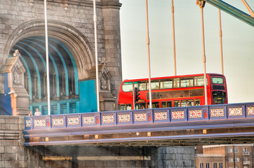 Red bus crossing Tower Birdge on a beautiful afternoon, London