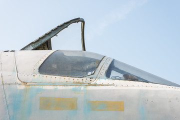 Fuselage and cockpit of an old jet fighter on sky background. Fragment. Detail of an old camouflage...