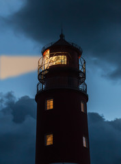 Sea lighthouse with a ray of light at night