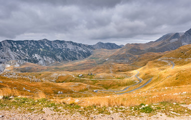 Rocky mountains covered with autumn meadow against the background of a stormy sky