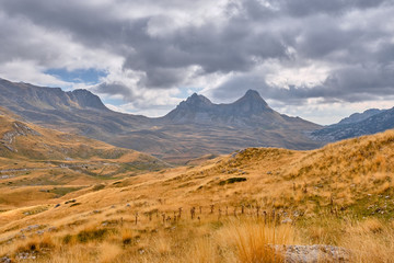 Rocky mountains covered with autumn meadow against the background of a stormy sky