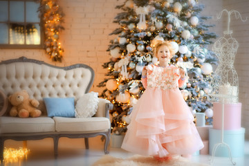 5 years old girl looking at her new light pink dress in christmas time