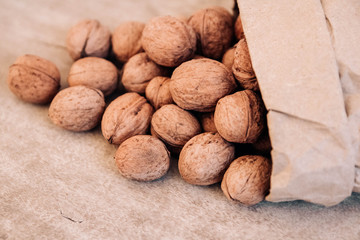 Walnuts in a paper bag on a old rustic table. Walnuts in a paper bag. Top view. Copy, empty space for text