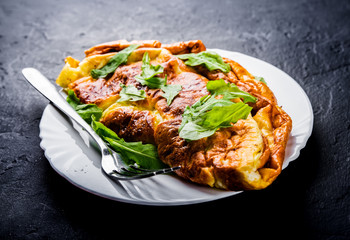omelet in white plate on Dark grey black slate background