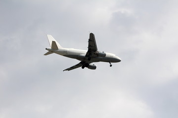 Large commercial passenger airplane flying overhead after take off from local airport surrounded...