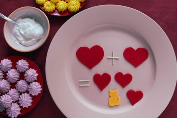Arithmetic of love. Sweet table with hearts on a plate