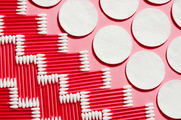 Hygiene products: round white cotton pads and cotton swabs are on colored background