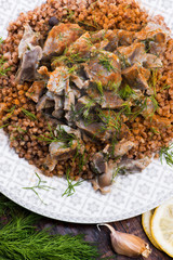 Fototapeta na wymiar Stewed turkey stomachs with vegetables and buckwheat in a bowl